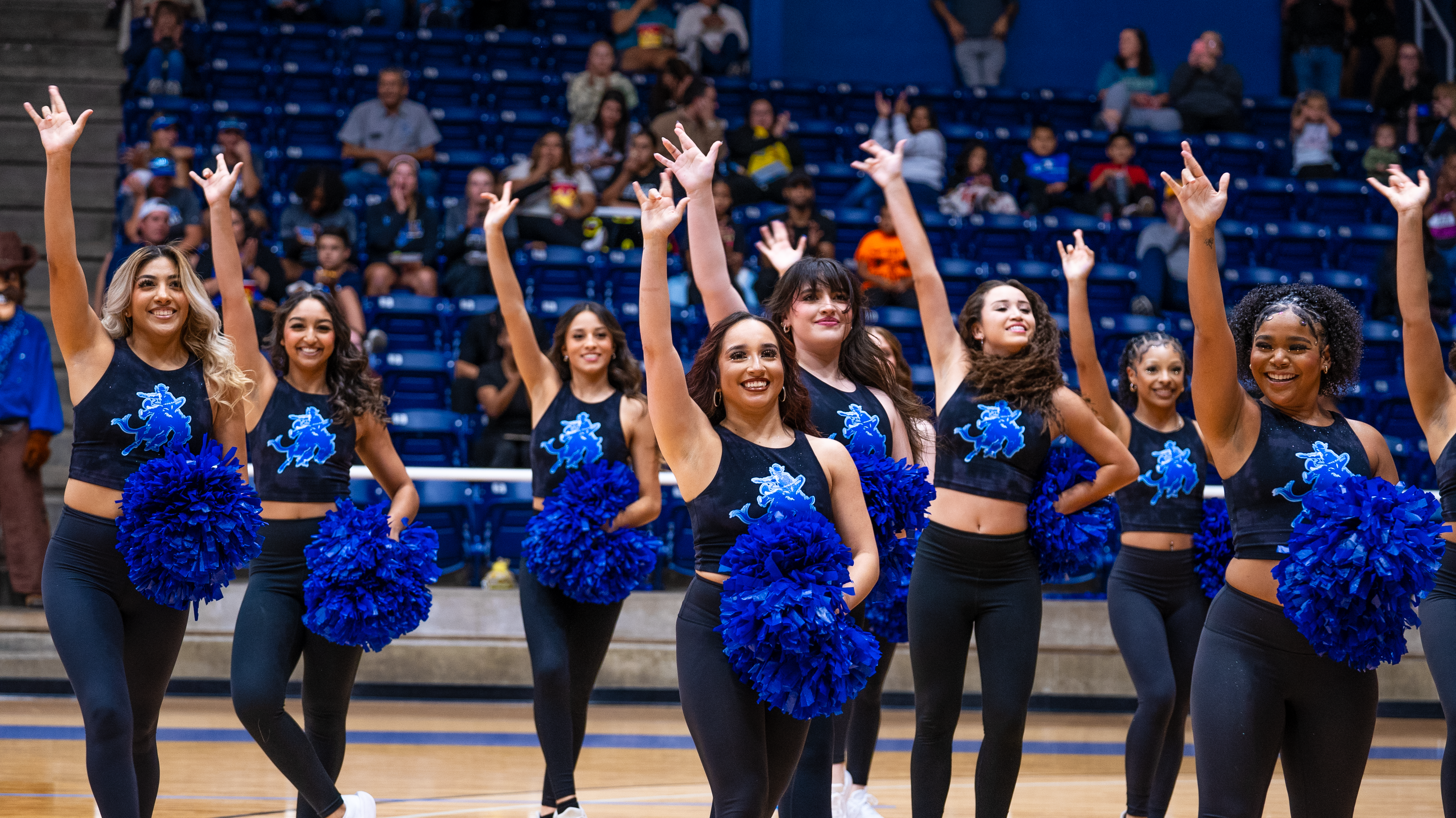Oc blues at a game doing the wrangler sign