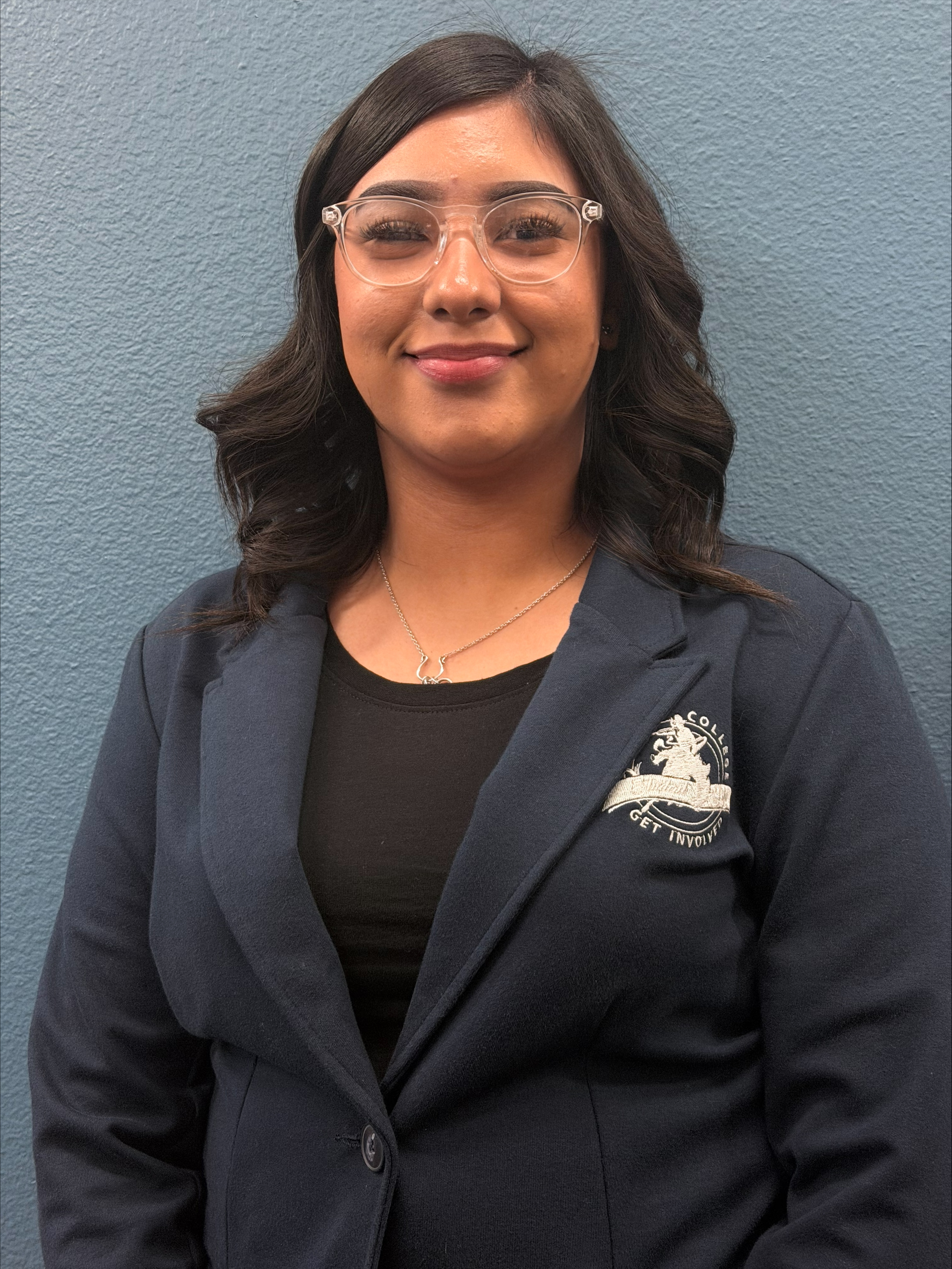 Photo of young woman with clear glasses and a necklace