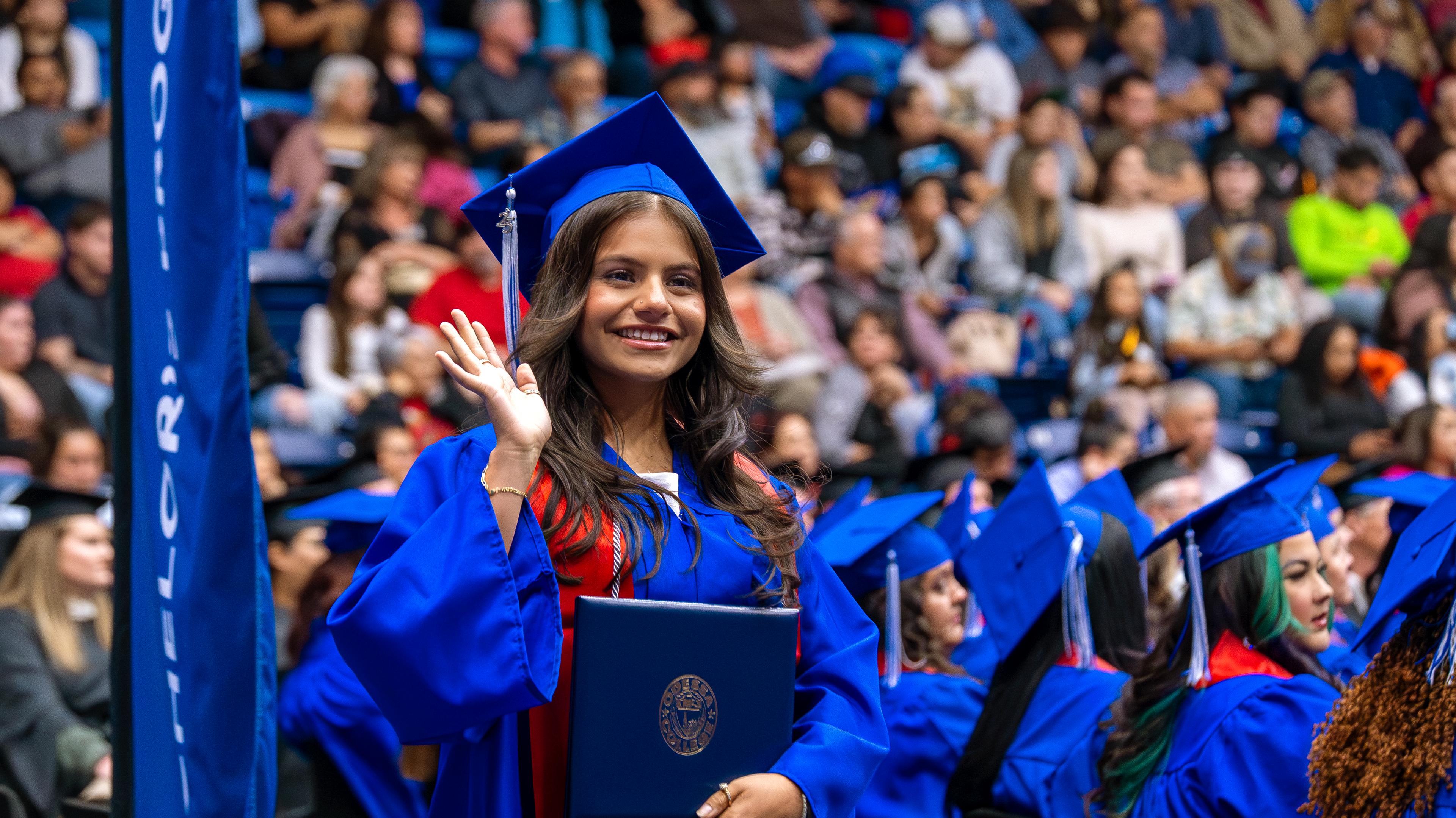 Student waving at graduation ceremony
