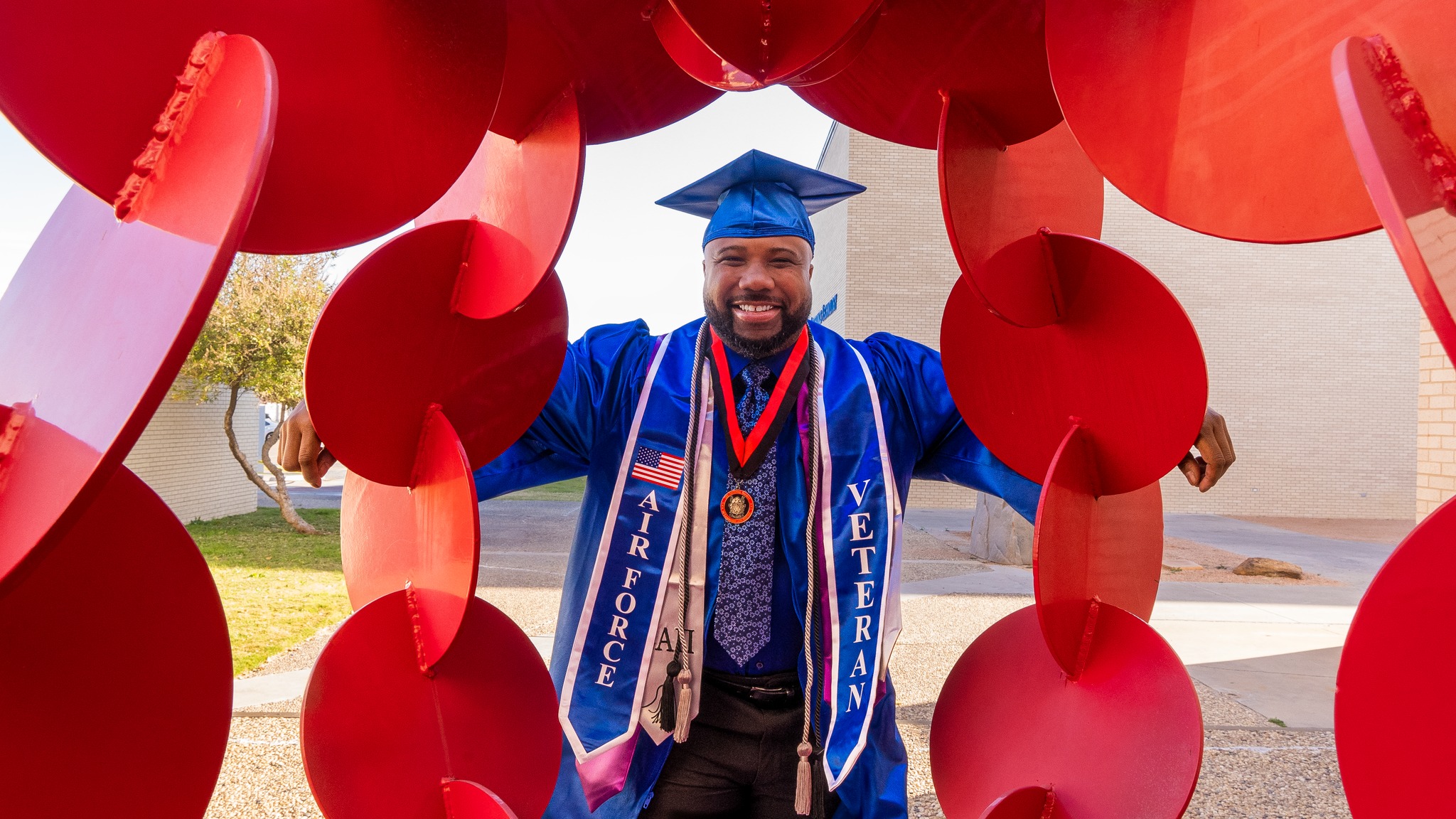 Kory Grant posing behind red statue