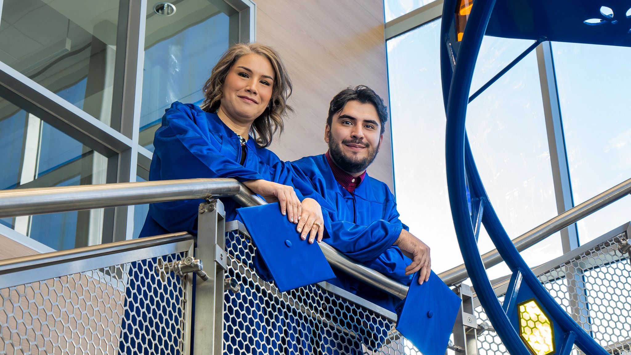 Sendra and Cesar Rios posing by a stair railing