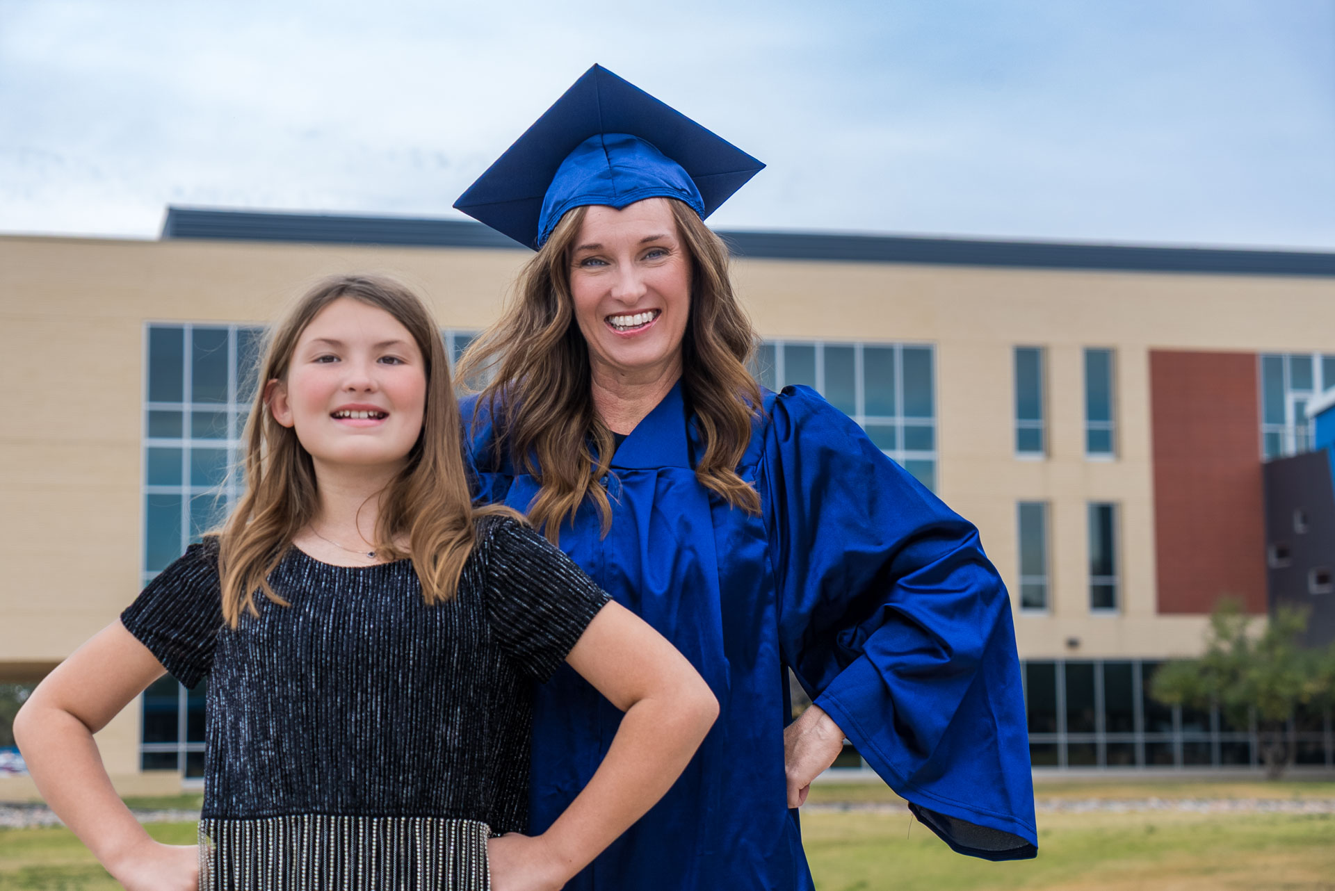 Candy Duke and daughter posing in front of a building