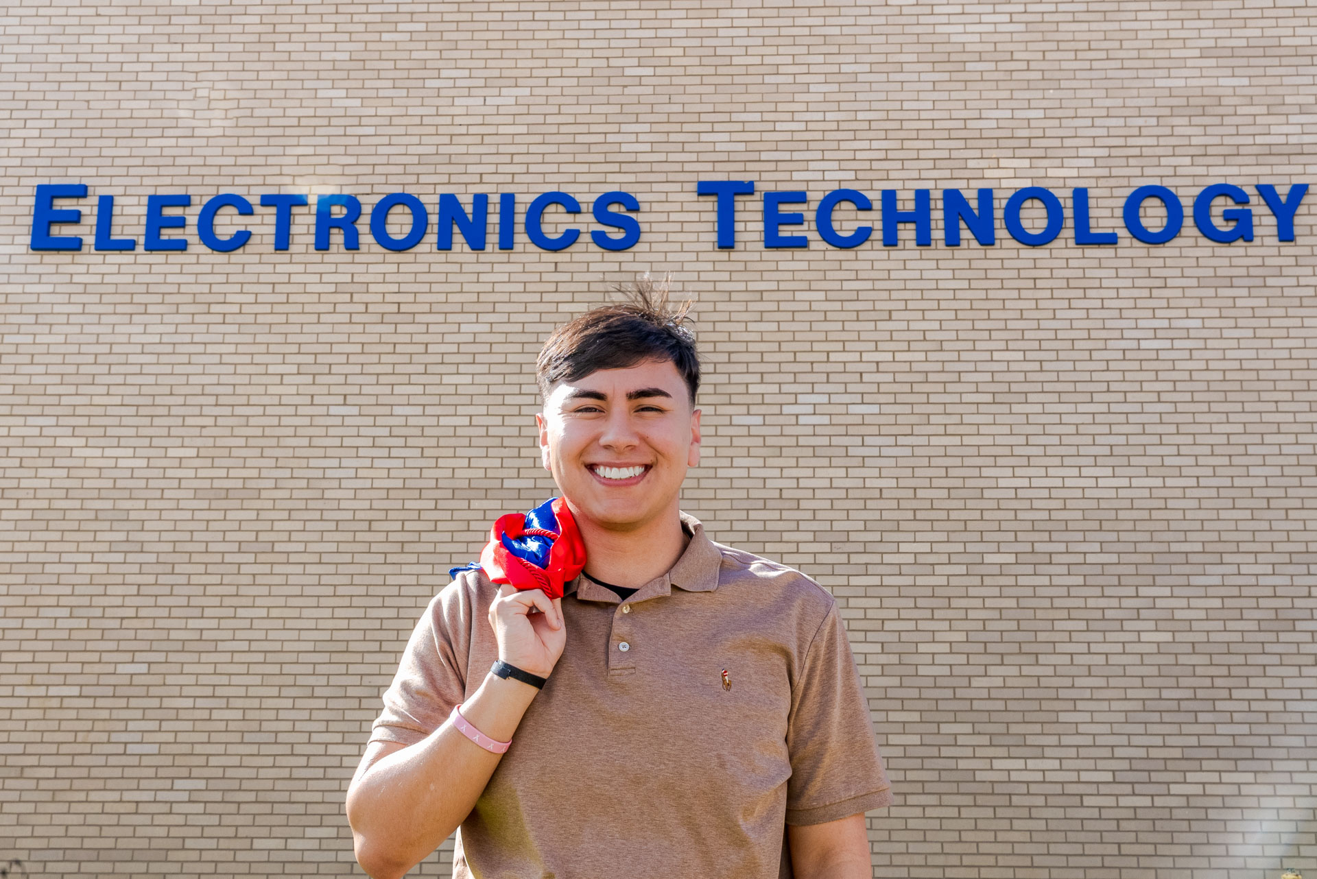 Raul Barrera smiling in front of ET building sign