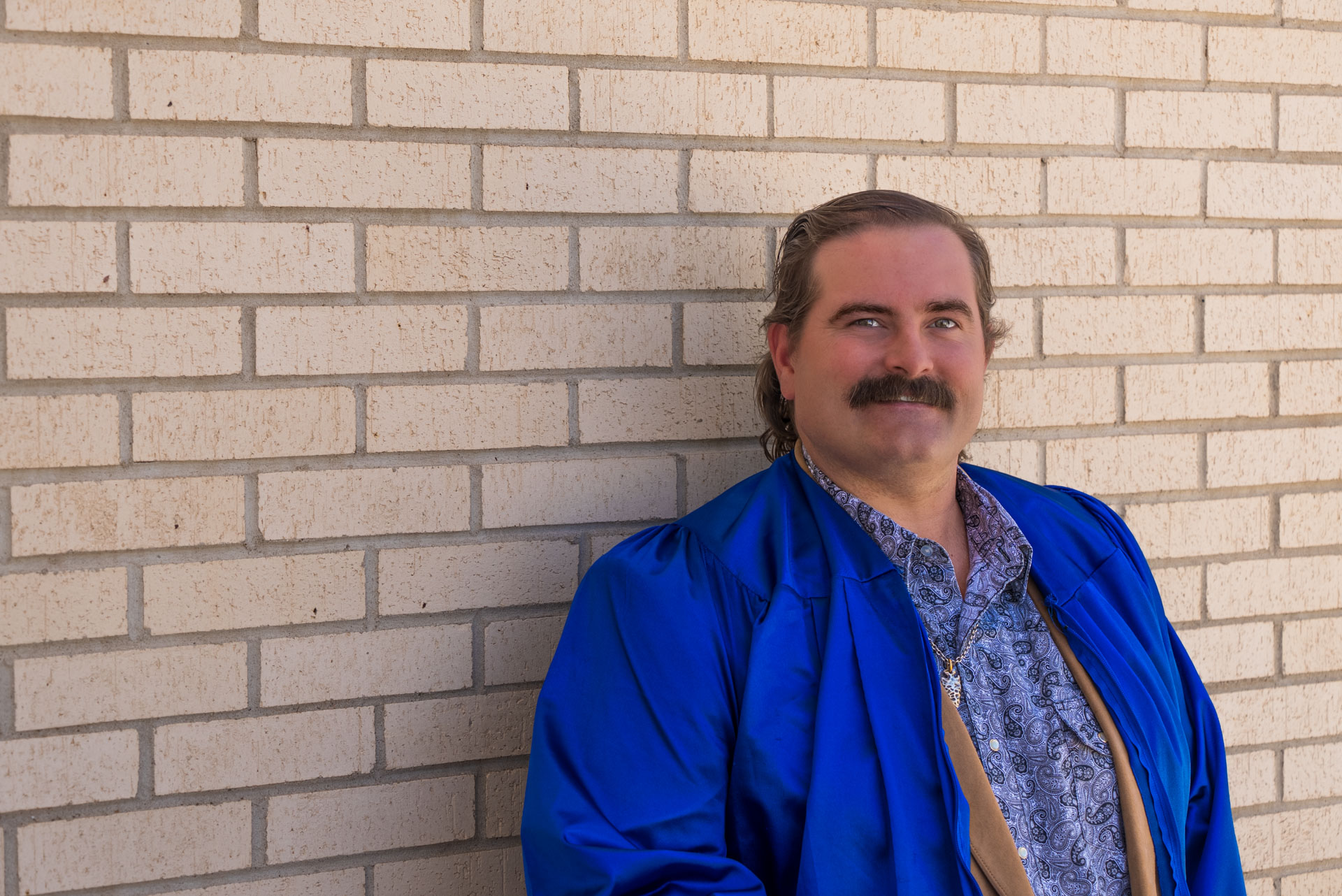Dustin Howard leaning against brick wall