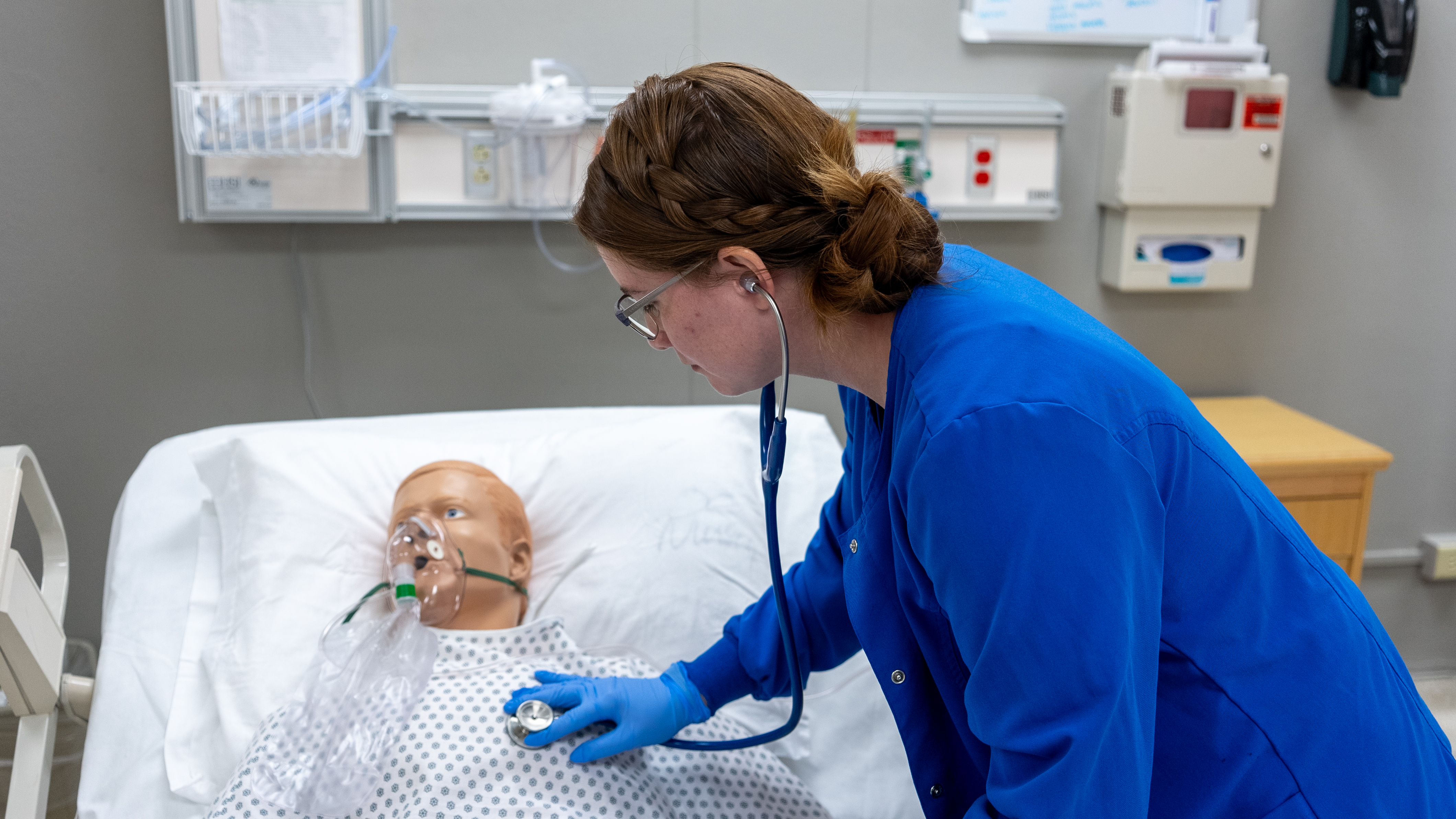 nurse checking vitals on a manequin 