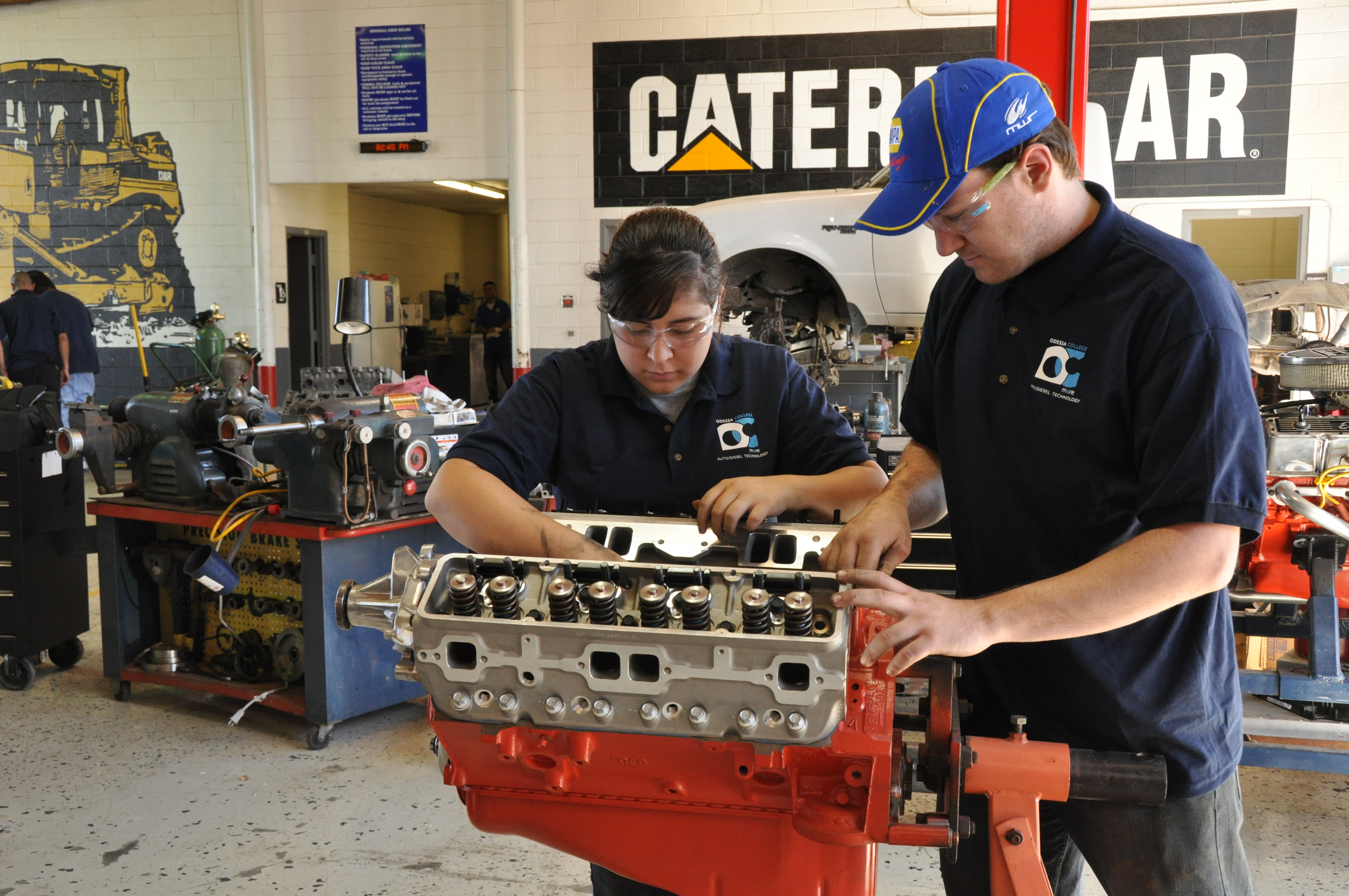 two auto tech students working on a motor