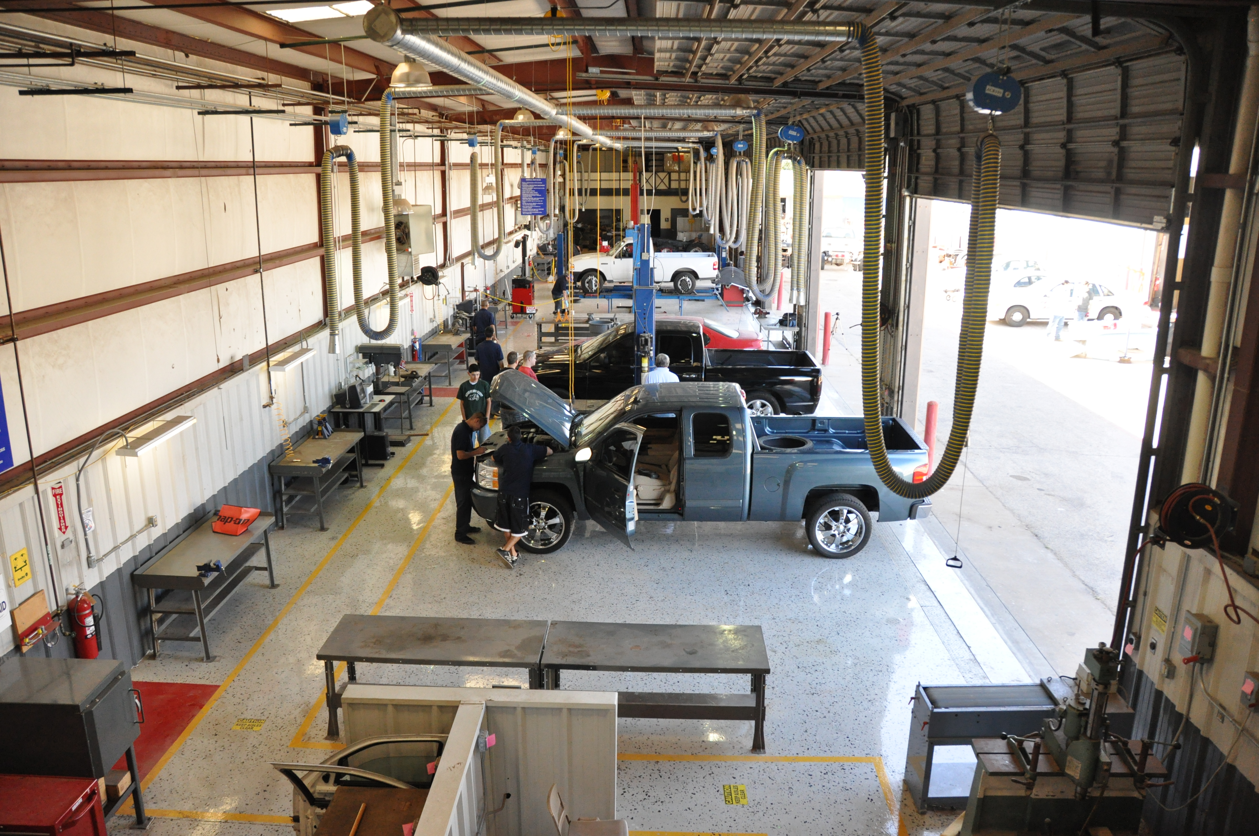 Automoviles in line as auto tech students work with them