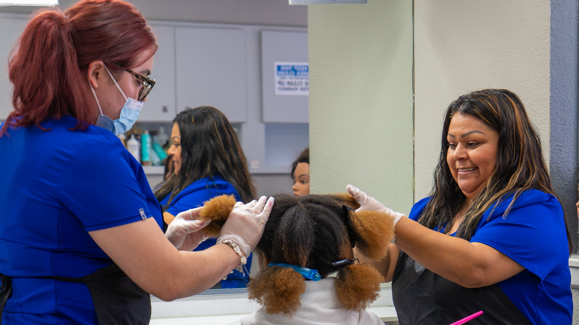 Two women working on afro hair